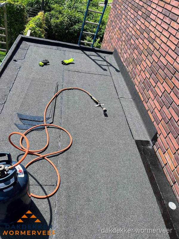 Plat dak met bitumen en brandgereedschap van dakdekkersbedrijf in Wormerveer Plat dak met bitumen en brandgereedschap van dakdekkersbedrijf in Wormerveer